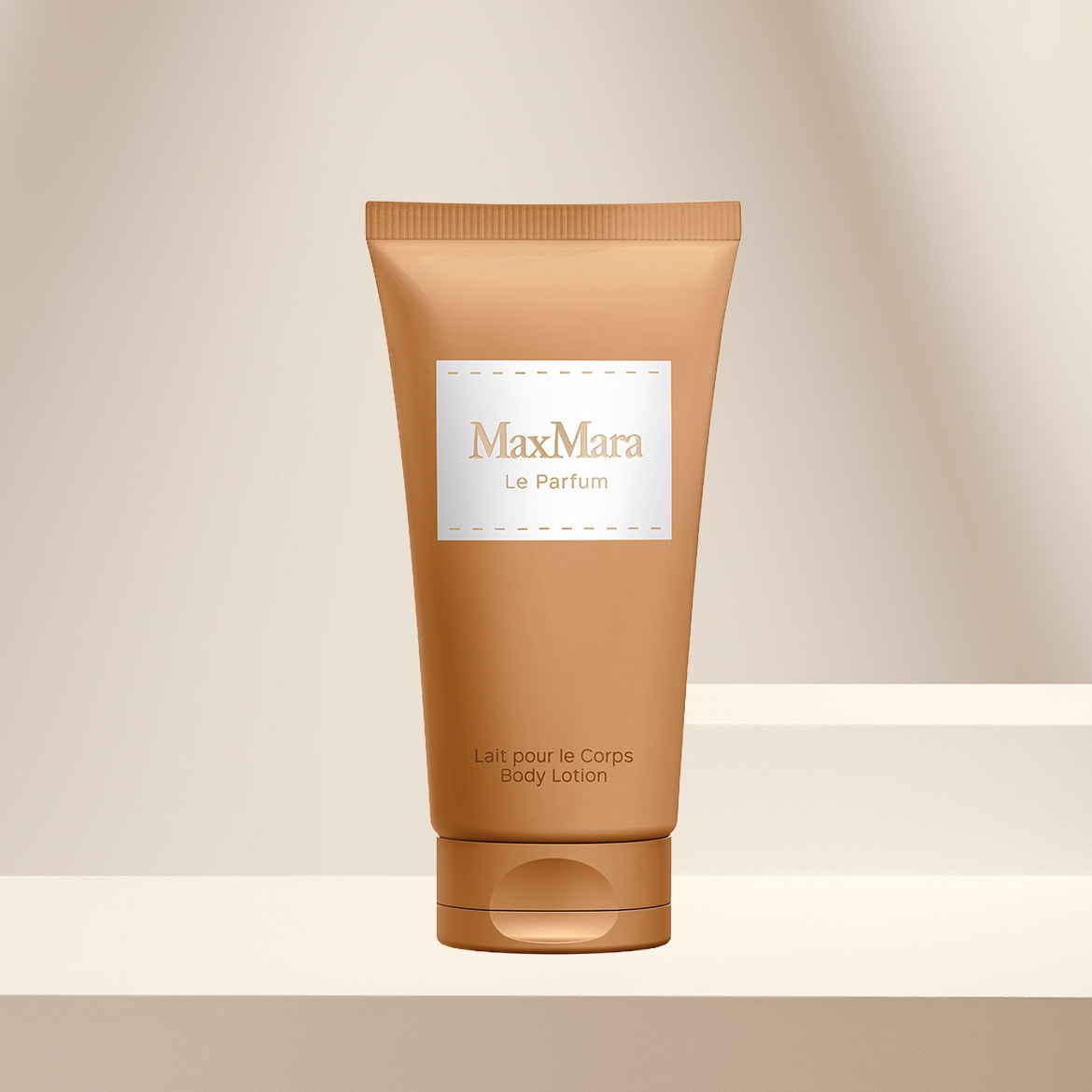 Die Max Mara Le Parfum Body Lotion in einer beigefarbenen Tube mit weißem Etikett und goldener Schrift, die auf einem hellbeigen Podest steht, spendet der Haut Feuchtigkeit und parfümiert sie zart.