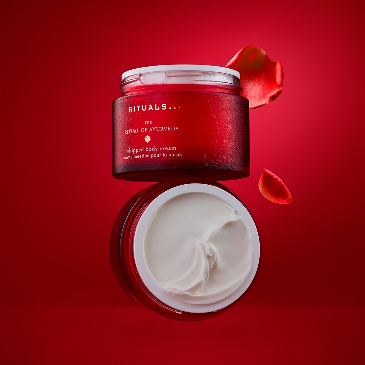 Entdecke die Ritual of Ayurveda Whipped Body Cream von Rituals in einer roten Dose mit weißem Deckel, die für ein luxuriöses Pflegeerlebnis sorgt.