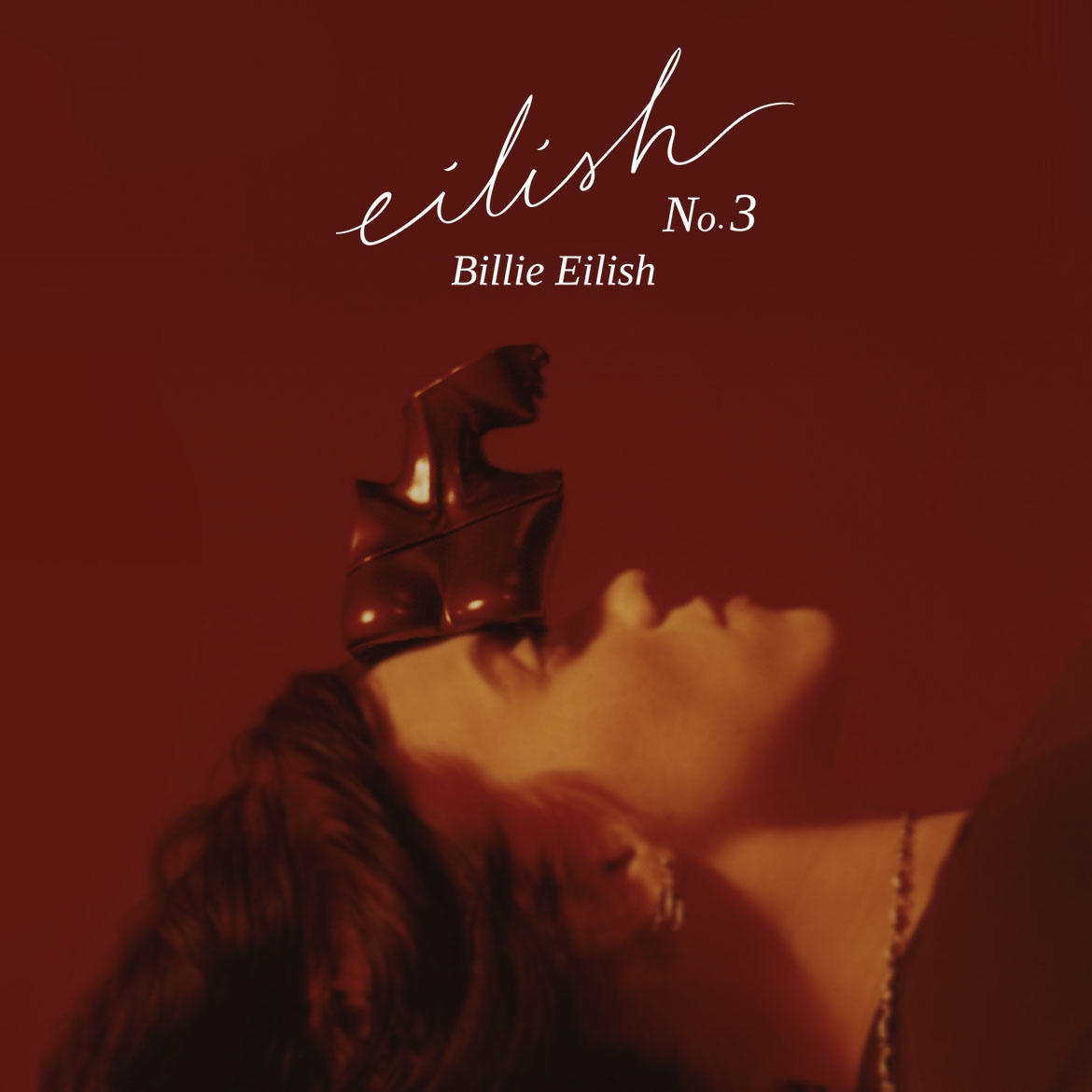 Das Bild zeigt Billie Eilish No. 3 Duft mit einer Skulptur auf ihrem Kopf, die die Flasche darstellt, vor einem roten Hintergrund.