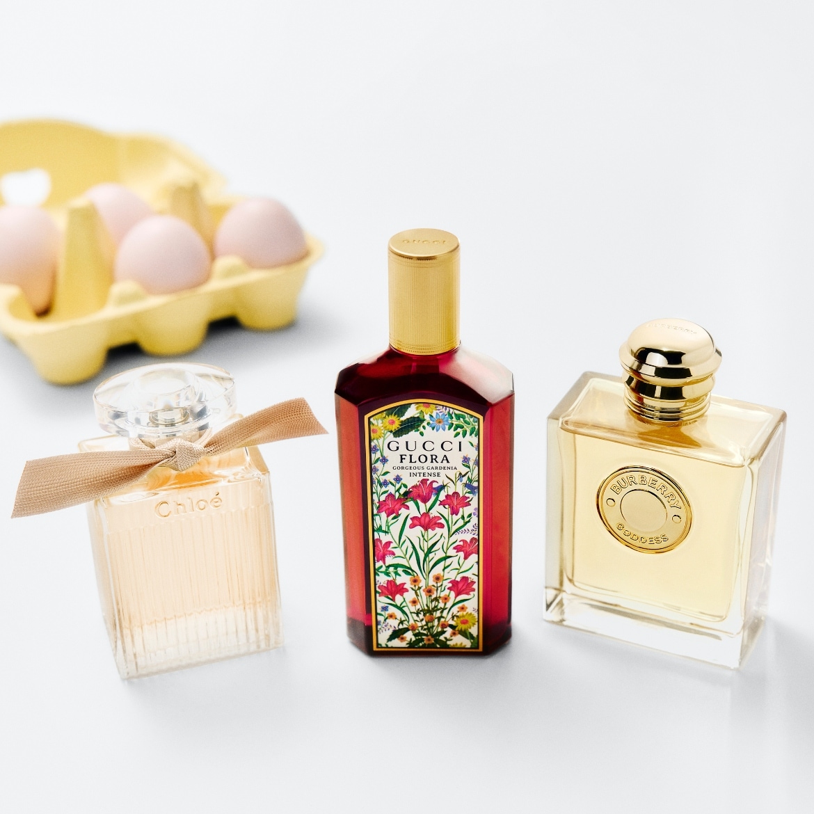 Entdecke eine Auswahl an Düften, darunter Chloé mit einer Schleife, Gucci Flora mit floralem Design und Burberry Goddess in goldenen Flakons.