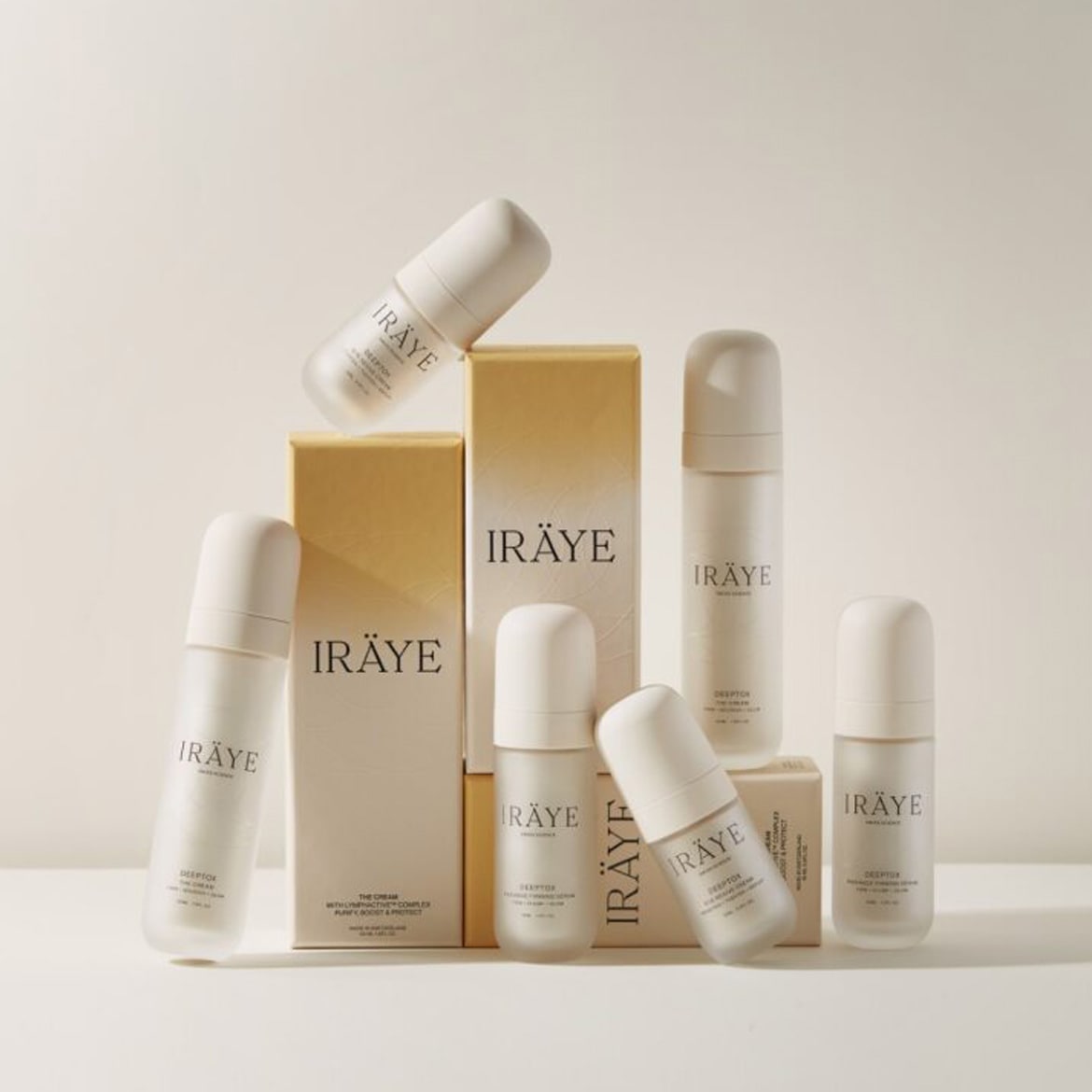 Displayed are multiple Iräye skincare products, featuring white bottles and cream-colored boxes, designed to purify, boost, and protect the skin.