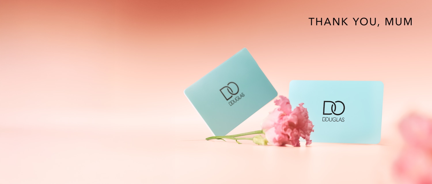 Zwei hellblaue Douglas-Geschenkkarten stehen neben einer rosa Nelke auf einem rosa Hintergrund, mit dem Text „DANKE, MAMA“ oben rechts.
