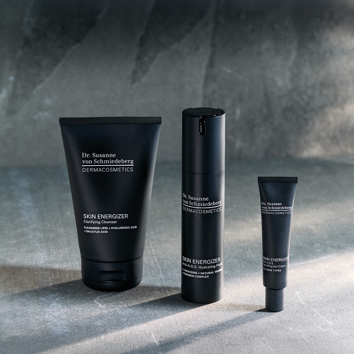 Entdecke das Dr. Susanne von Schmiedeberg DERMACOSMETICS Hautpflege-Set in schwarzen Verpackungen, das einen klärenden Reiniger, ein feuchtigkeitsspendendes Fluid und eine Anti-Age-Augencreme enthält.