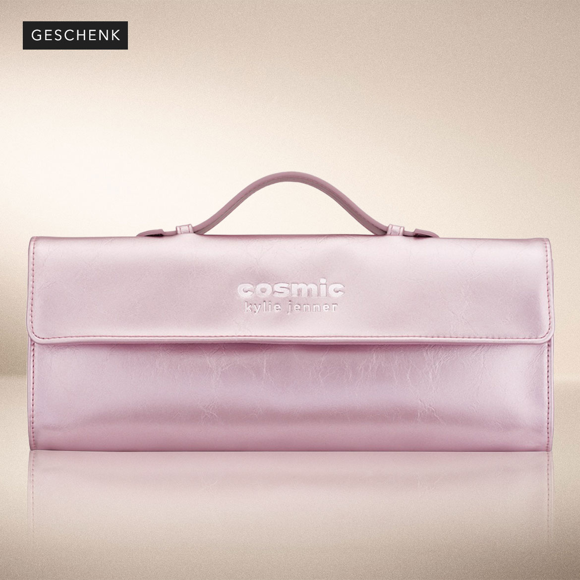 Hier ist eine Kosmetiktasche von Kylie Jenner in glänzendem Rosa mit einem Griff und der Aufschrift "Cosmic Kylie Jenner".
