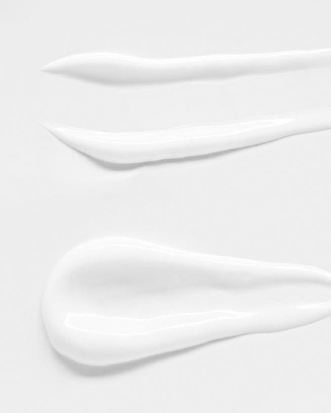 Nahaufnahme von weißen Sonnencremeproben, die die Textur und Konsistenz des Produkts hervorheben.'