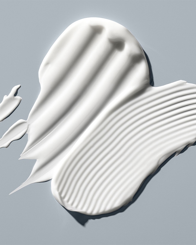 'Nahaufnahme von weißen Sonnencremeproben mit unterschiedlichen Texturen, die die Vielfalt der Hautpflege für verschiedene Hauttypen demonstrieren.