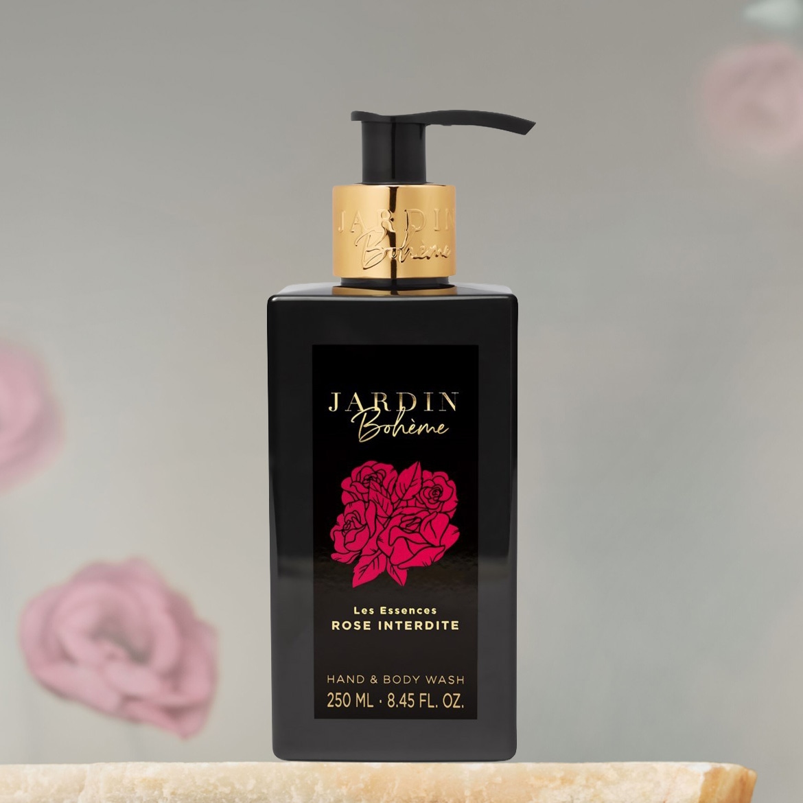 Schwarze Flasche Jardin Bohème Hand- und Körperwaschmittel Rose Interdite mit goldenem Verschluss und Etikett mit rosa Rosenblüten.