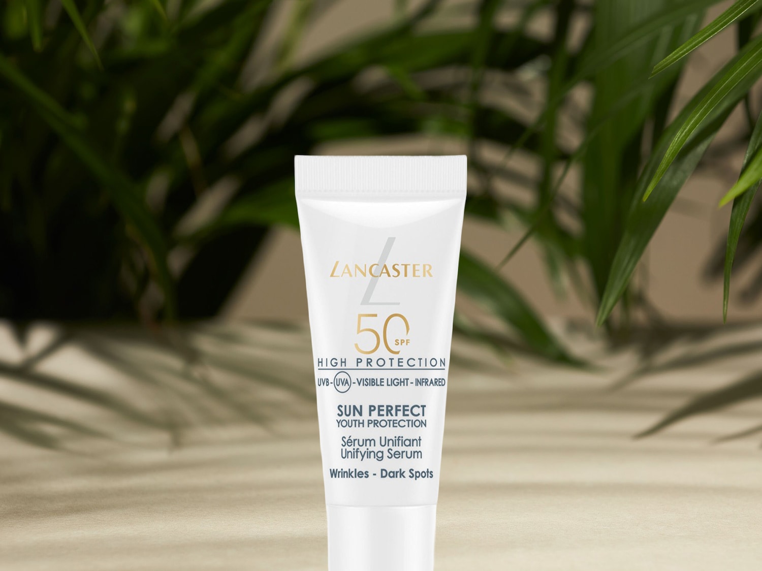 Die Lancaster Sun Perfect Youth Protection Unifying Serum mit LSF 50 in einer weißen Tube schützt die Haut vor UVB-, UVA-, sichtbarem Licht und Infrarotstrahlung, während sie Falten und dunkle Flecken reduziert.