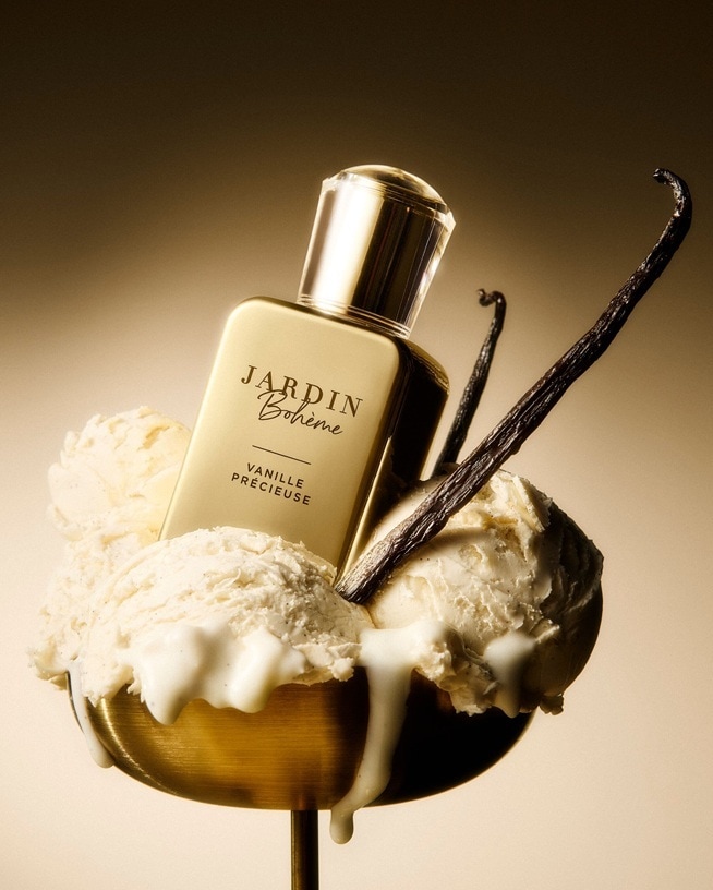Parfumflakon „Jardin Bohème – Vanille Précieuse“ steht in einer Schale mit schmelzendem Vanilleeis, flankiert von dunklen Vanilleschoten vor warmem, goldenem Hintergrund – ein visuelles Sinnbild für süsse, cremige Gourmand‑Düfte mit sinnlicher Tiefe.
