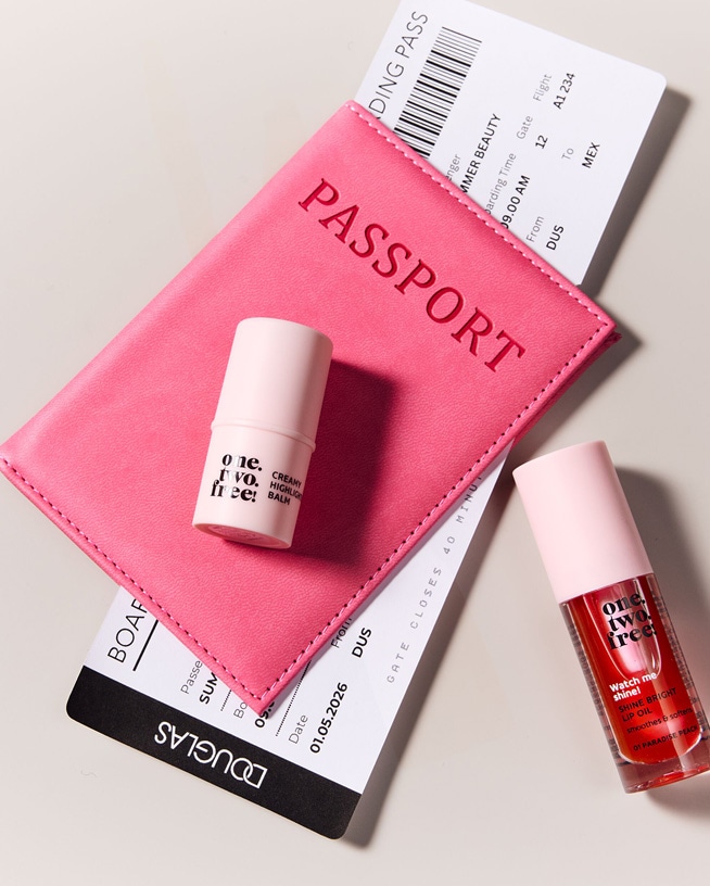 Mach dich bereit für deinen Urlaub mit diesem Reise-Kit, inklusive einem rosa Reisepass-Etui, einem cremigen Highlighter-Balm und einem glänzenden Lippenöl.